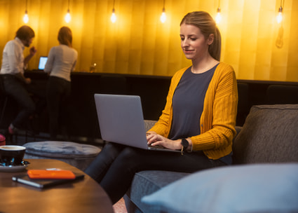Frau mit Laptop in Lounge